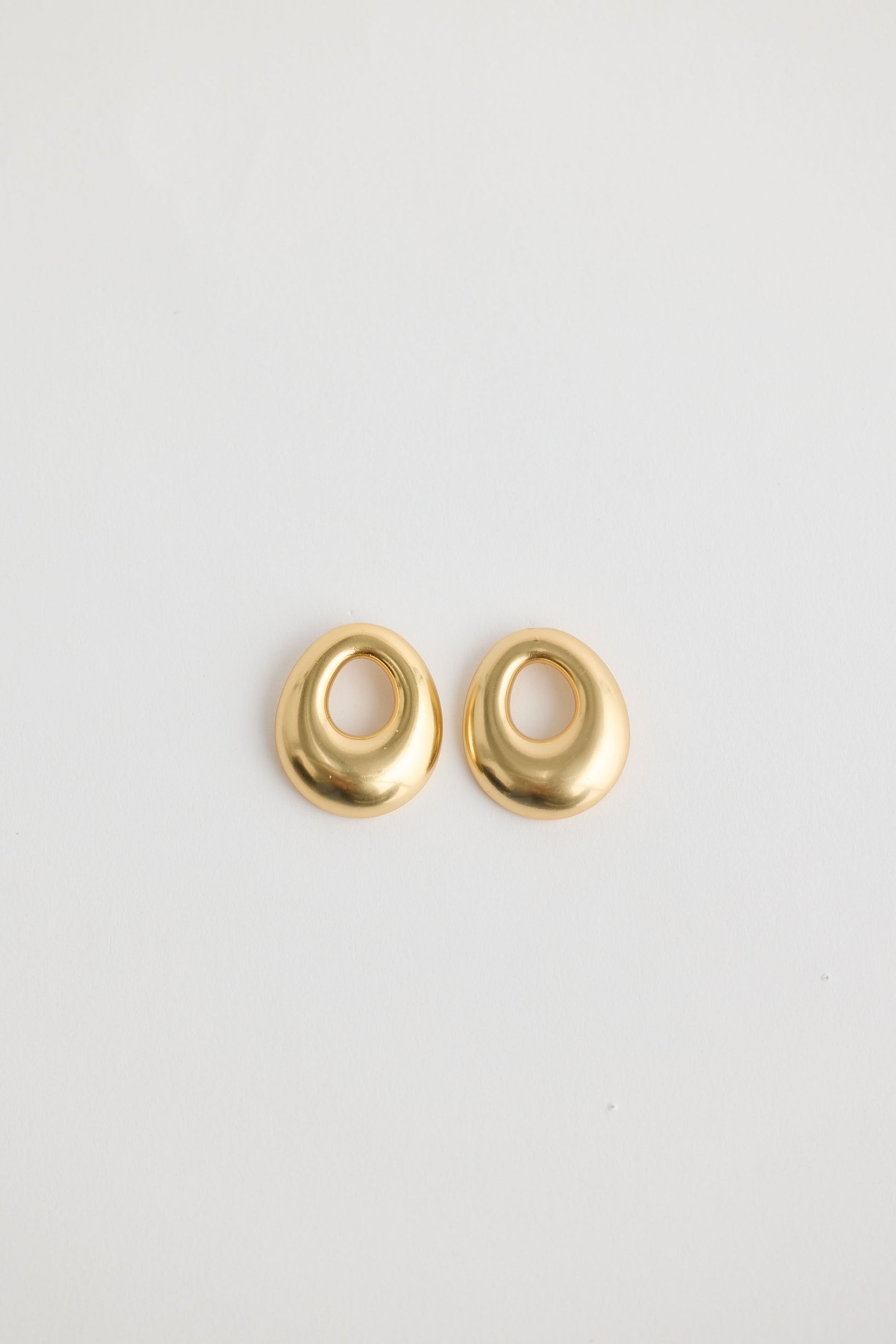 Close-up of gold jordan earrings earrings on white background.