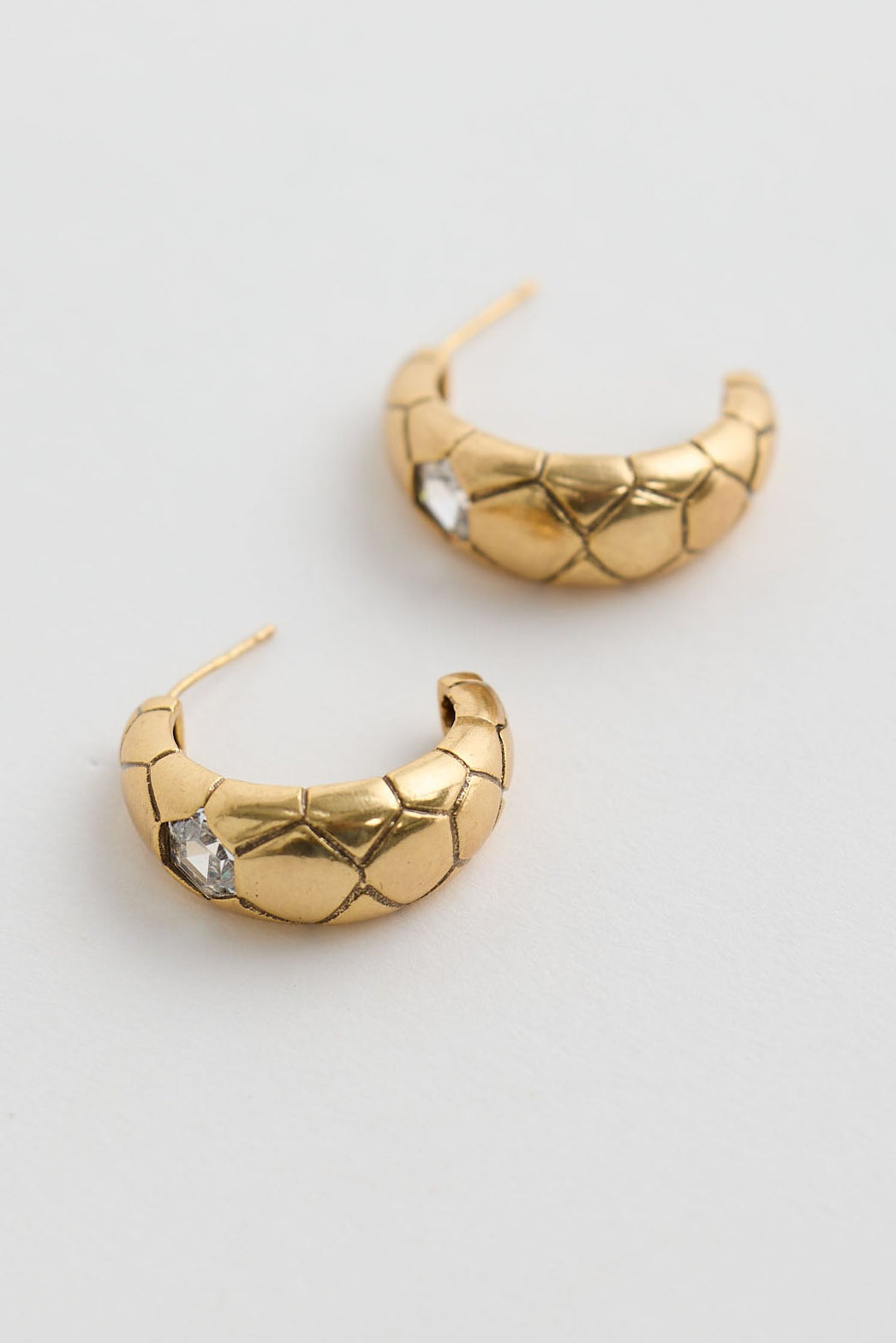 Close-up of gold morgan earrings earrings on white background.