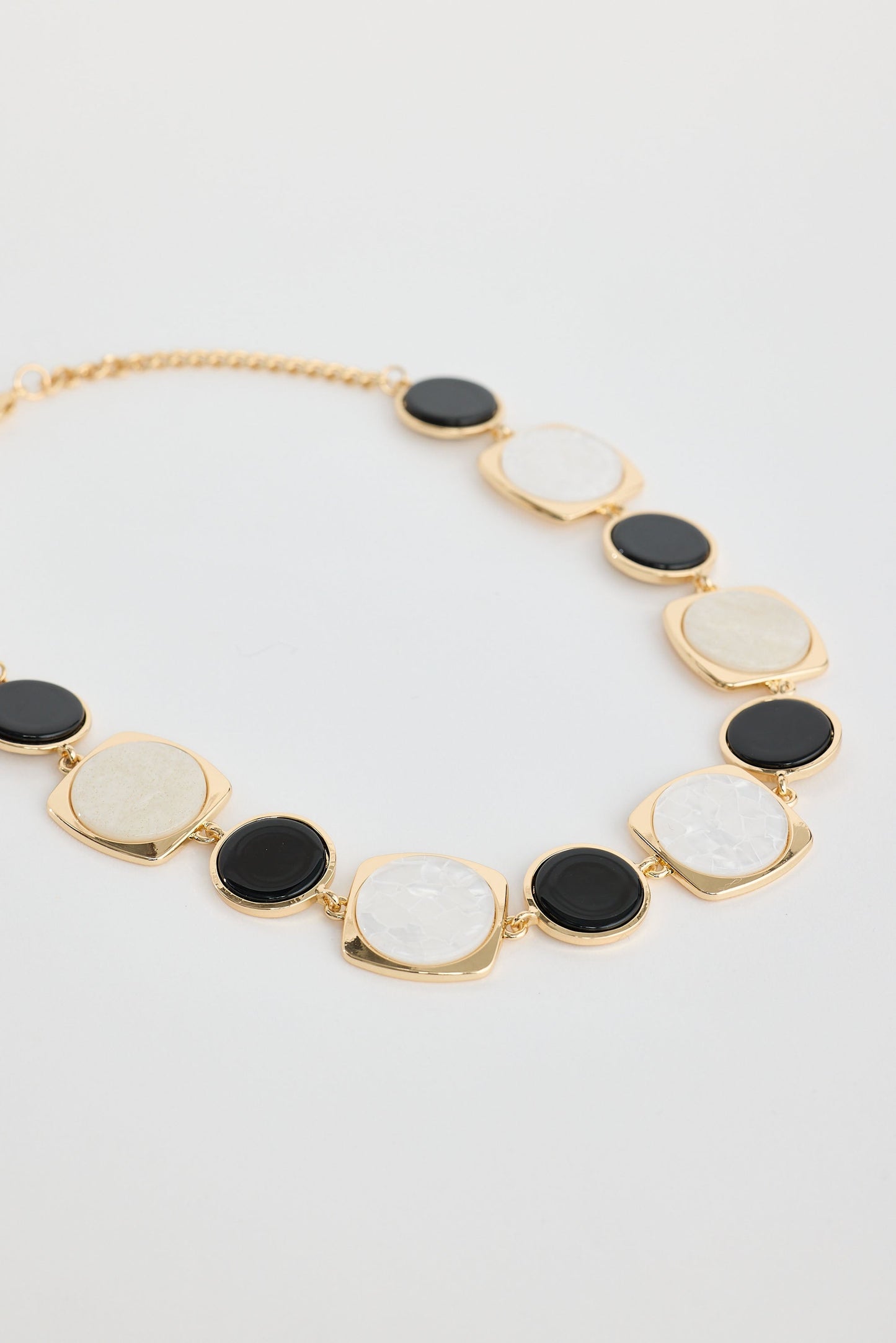 Close-up of black w white wendy necklace necklace on white background.