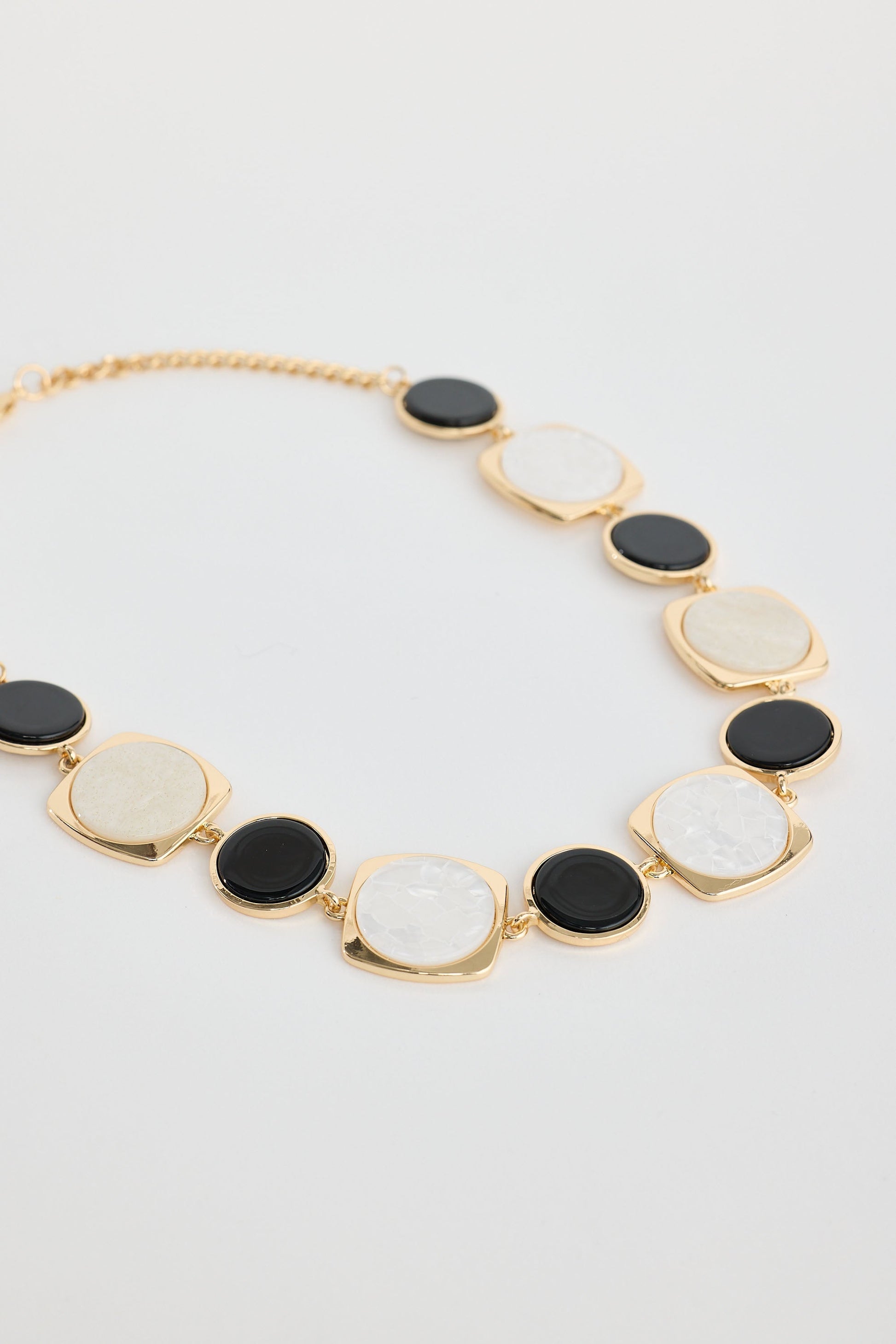 Close-up of black w white wendy necklace necklace on white background.