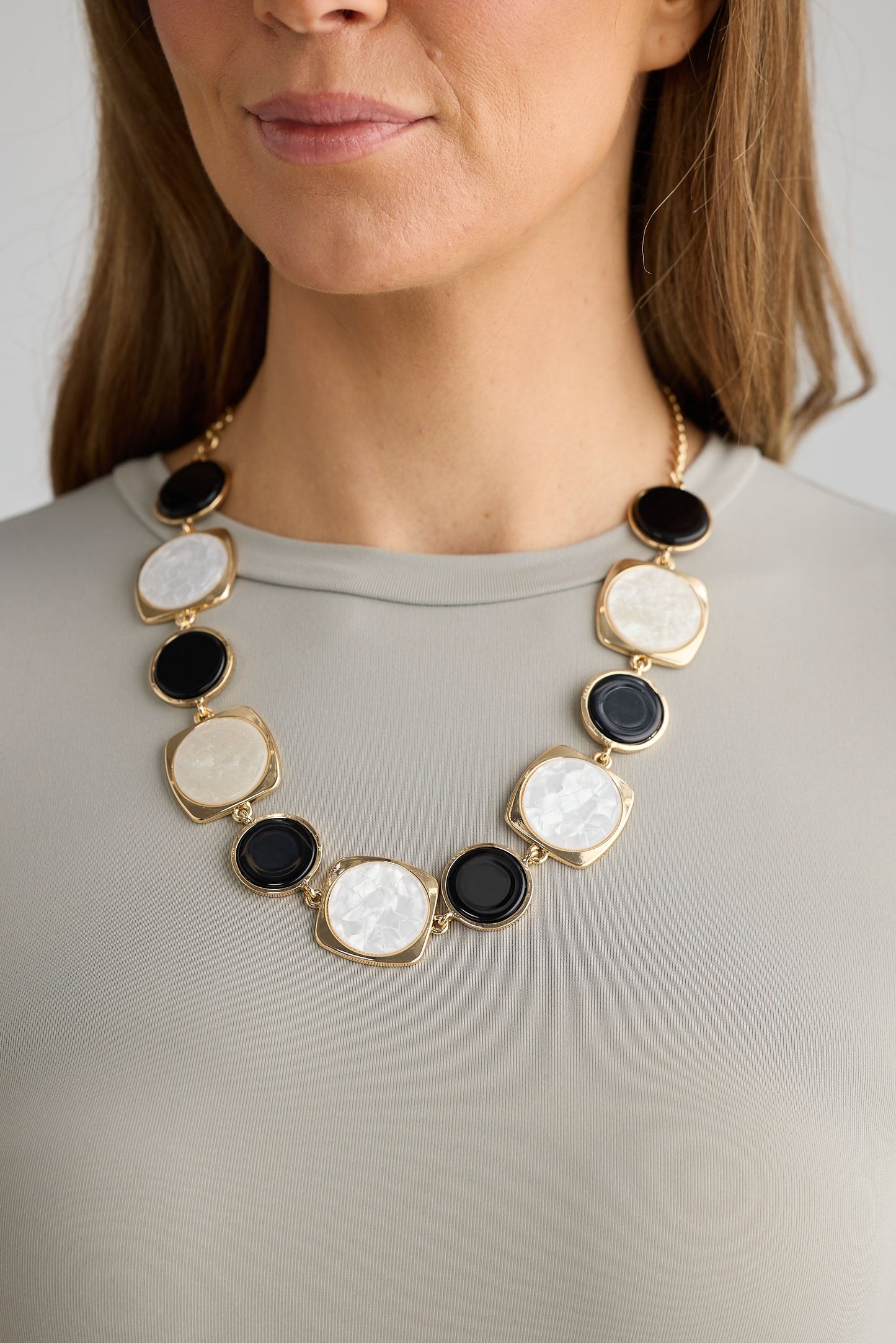 Close-up of black w white wendy necklace necklace on white background.