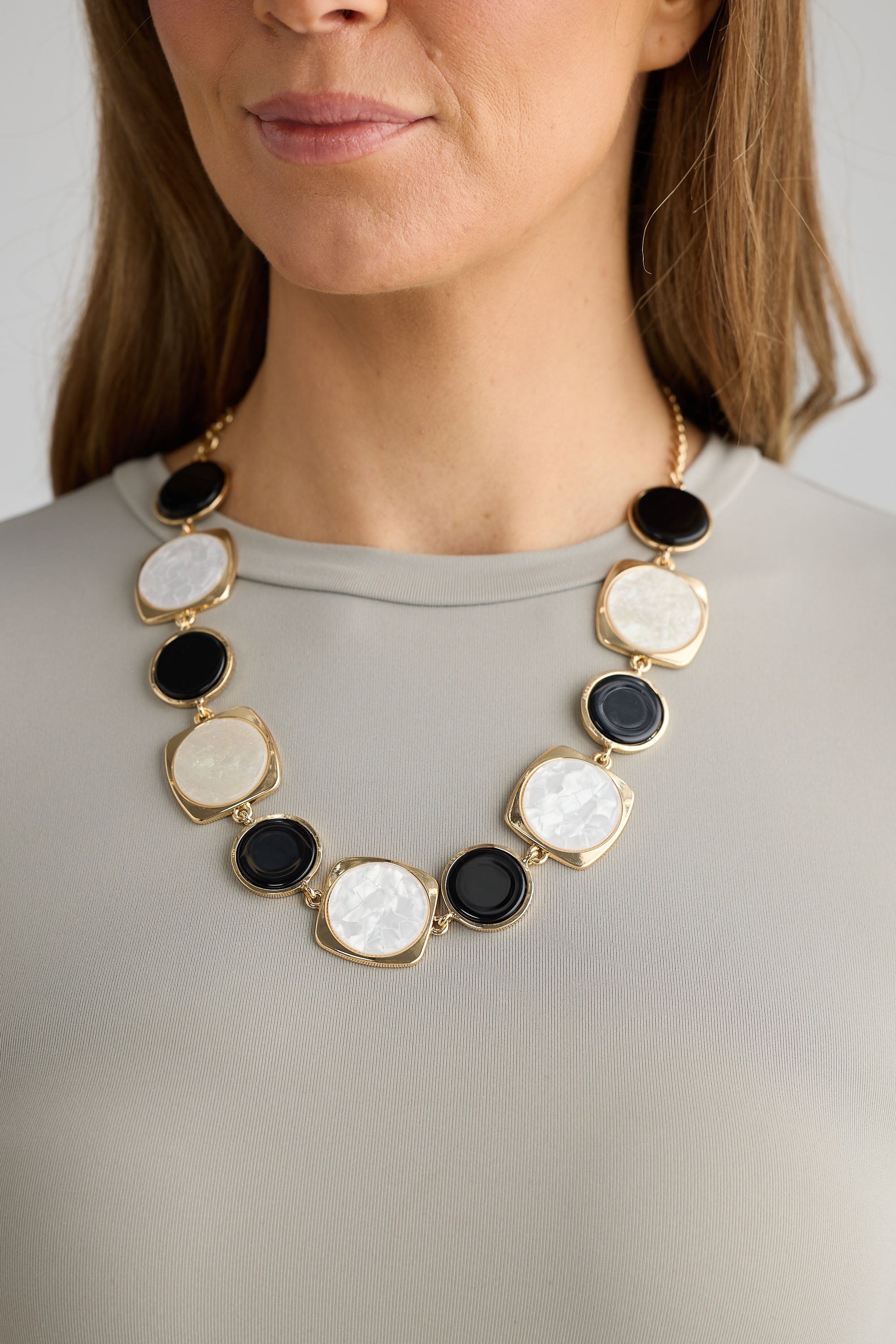 Close-up of black w white wendy necklace necklace on white background.