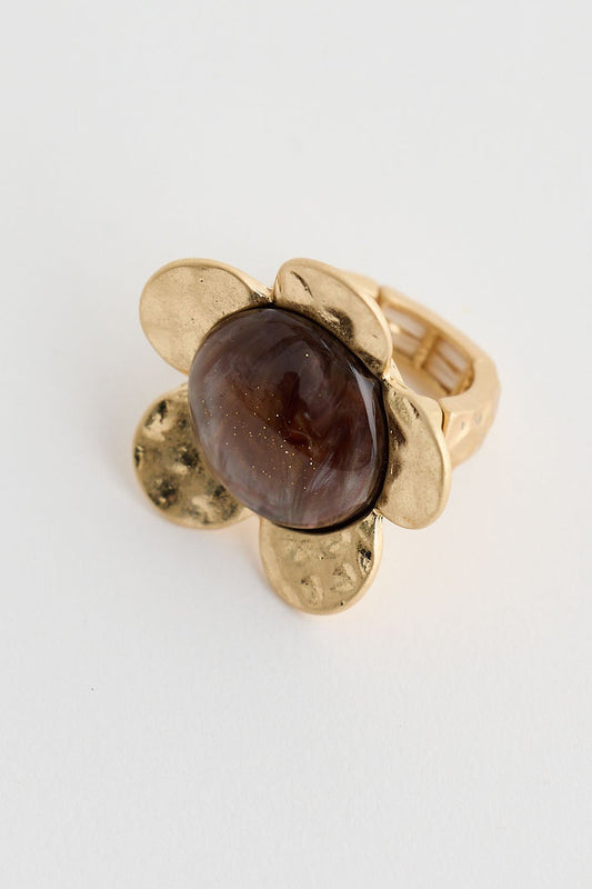Gold ring with a brown gemstone on a white background