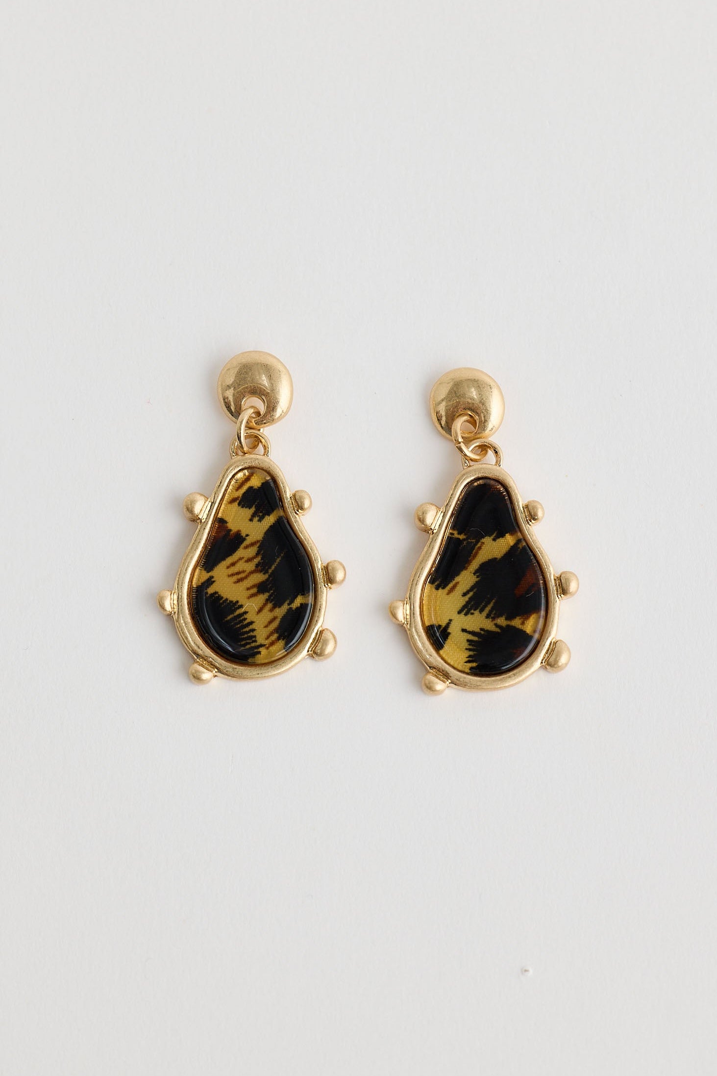 Pair of earrings with black and gold design on a white background