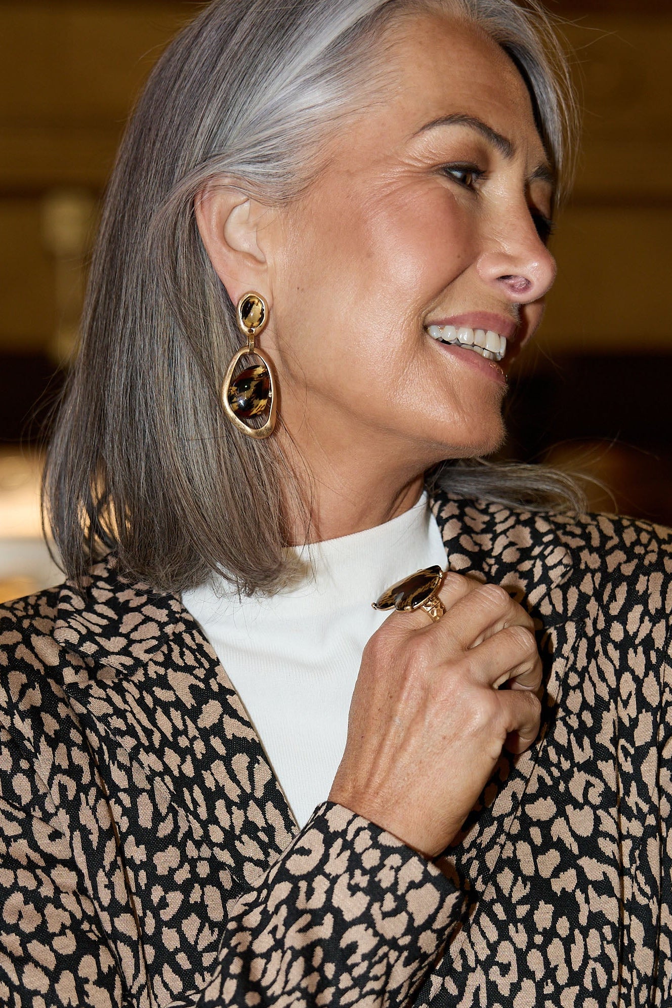 Woman wearing a leopard print jacket with a blurred indoor background
