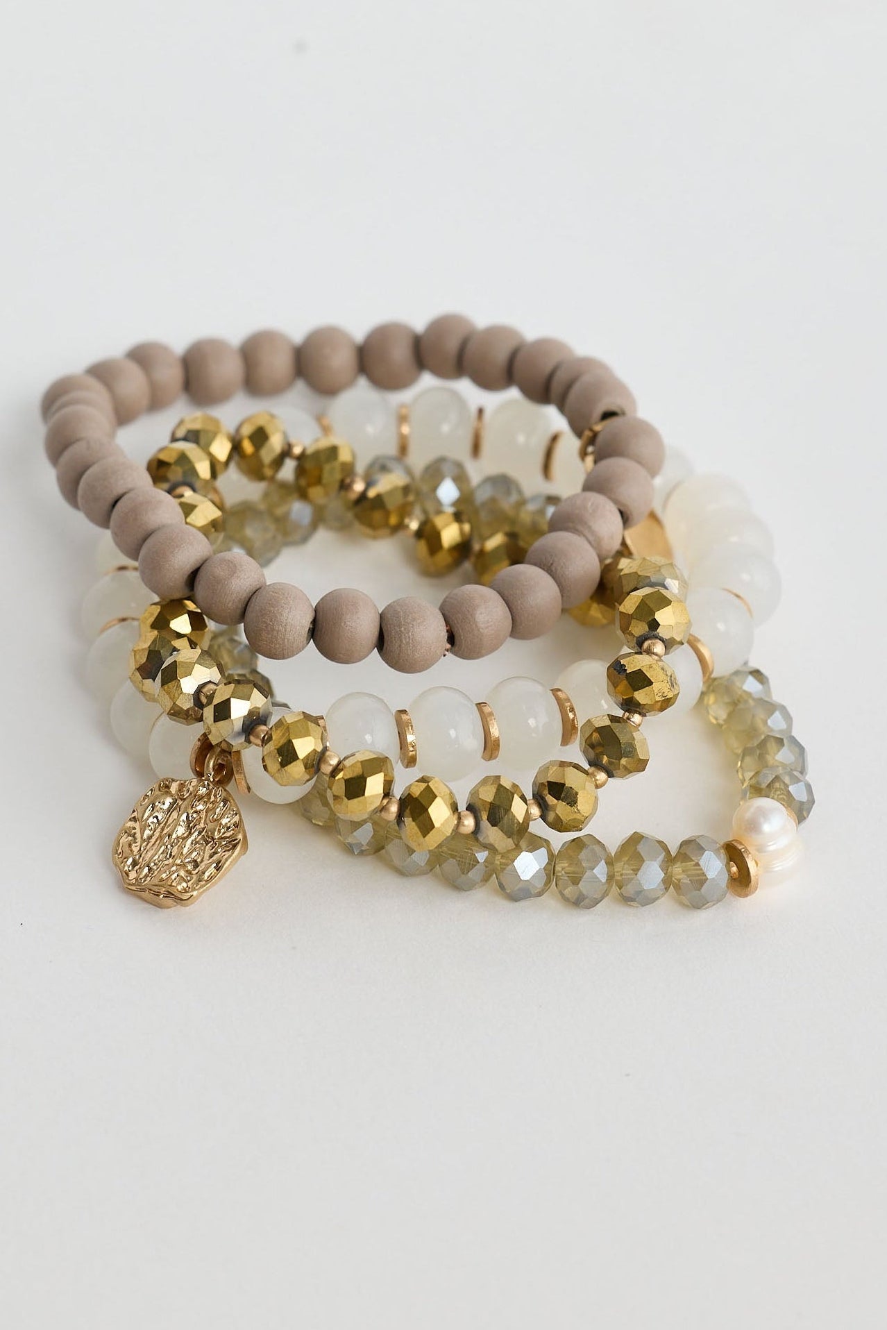 Set of beaded bracelets with gold accents on a light gray background