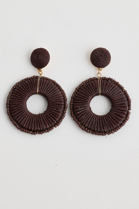 Pair of brown circular earrings on a white background