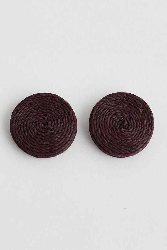 Pair of round dark brown earrings on a light gray background