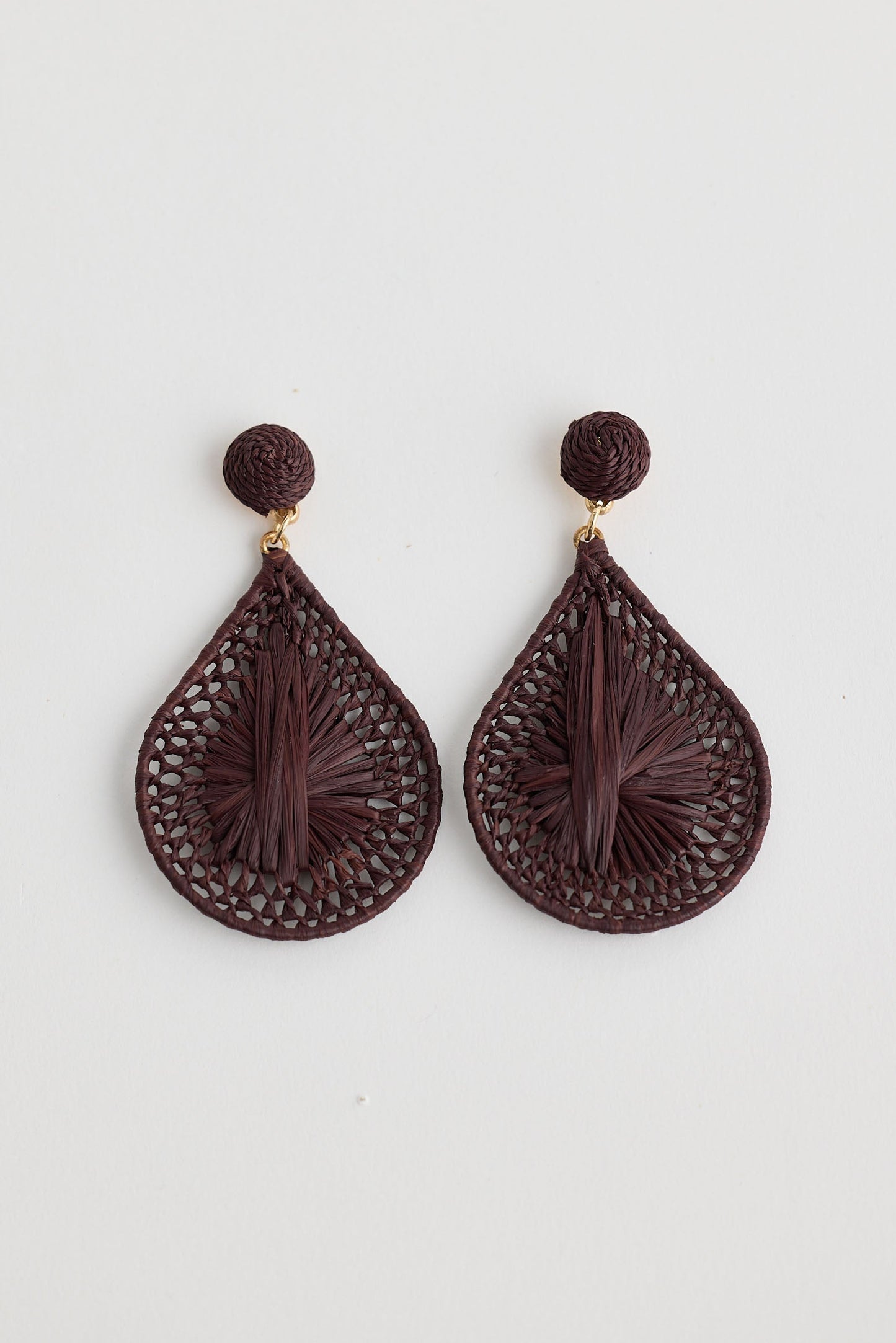 Pair of brown teardrop-shaped earrings on a light gray background