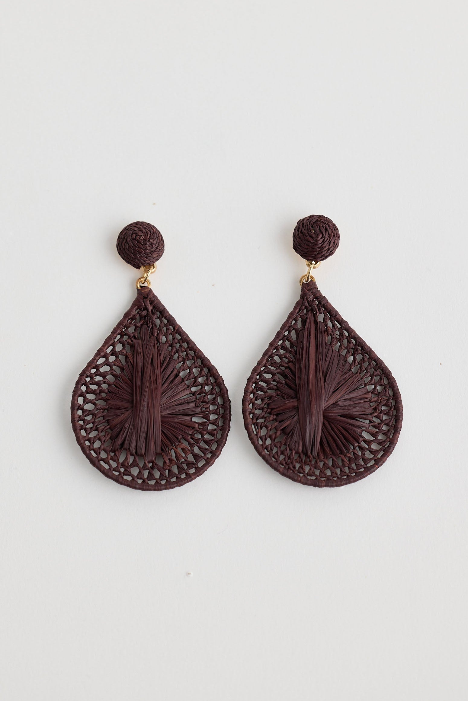 Pair of brown teardrop-shaped earrings on a light gray background