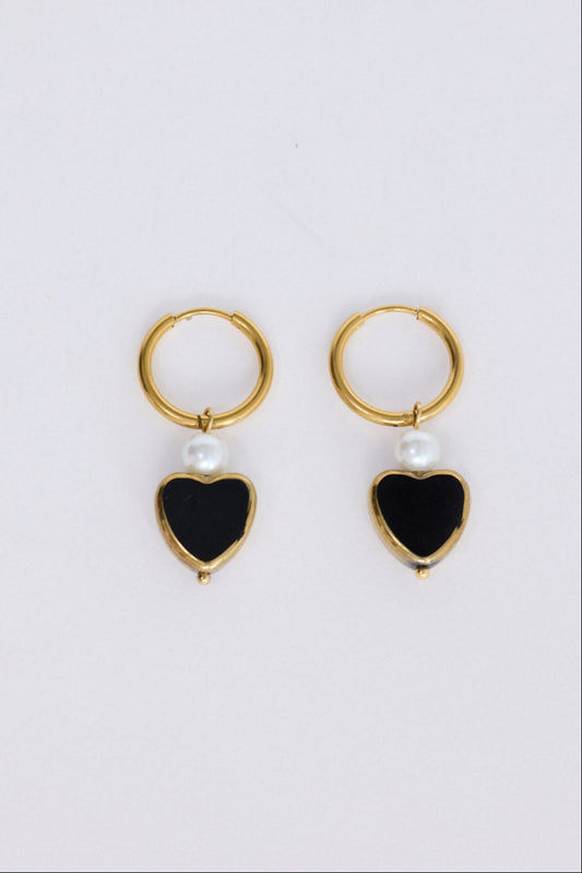 Mimi Earrings in black with bold heart charm detail, angled view on white background