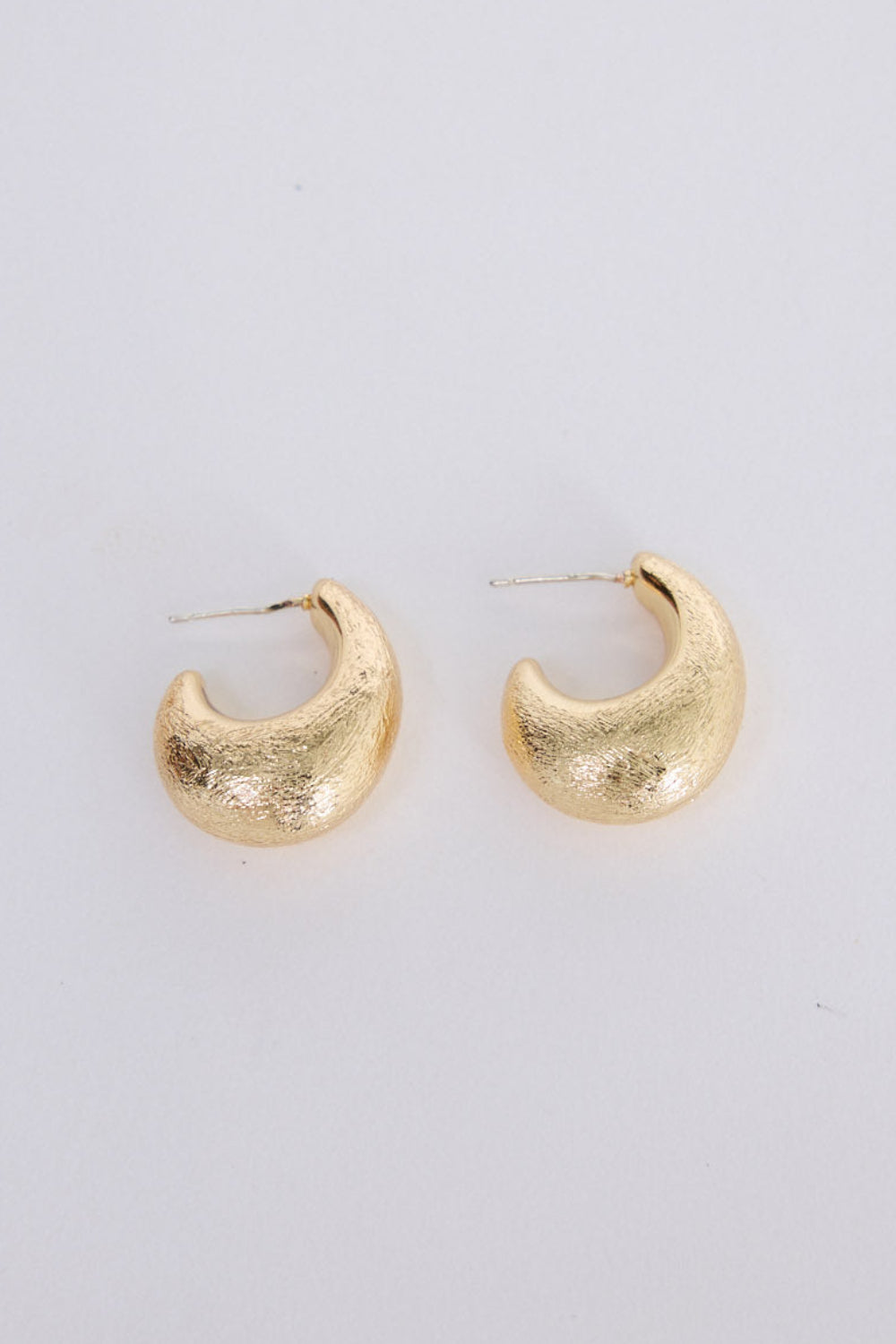Grace Earrings in gold with a textured finish, front view on white background
