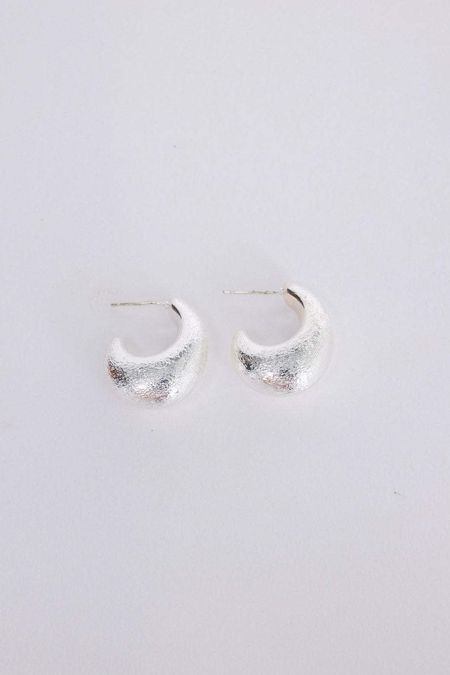 Grace Earrings in silver with a textured finish, angled view on white background