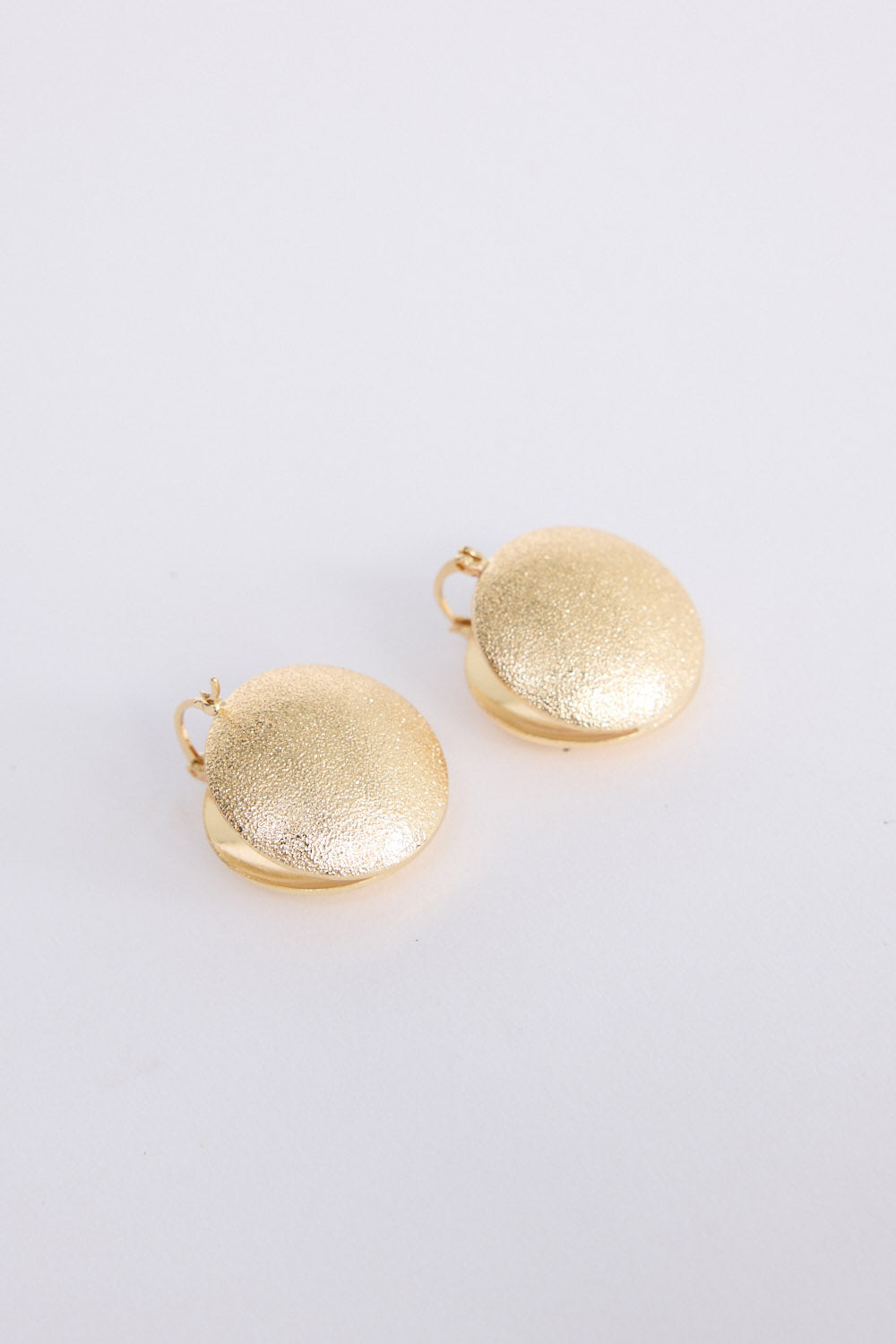 Sue Earrings in gold with a brushed textured finish, front view on white background