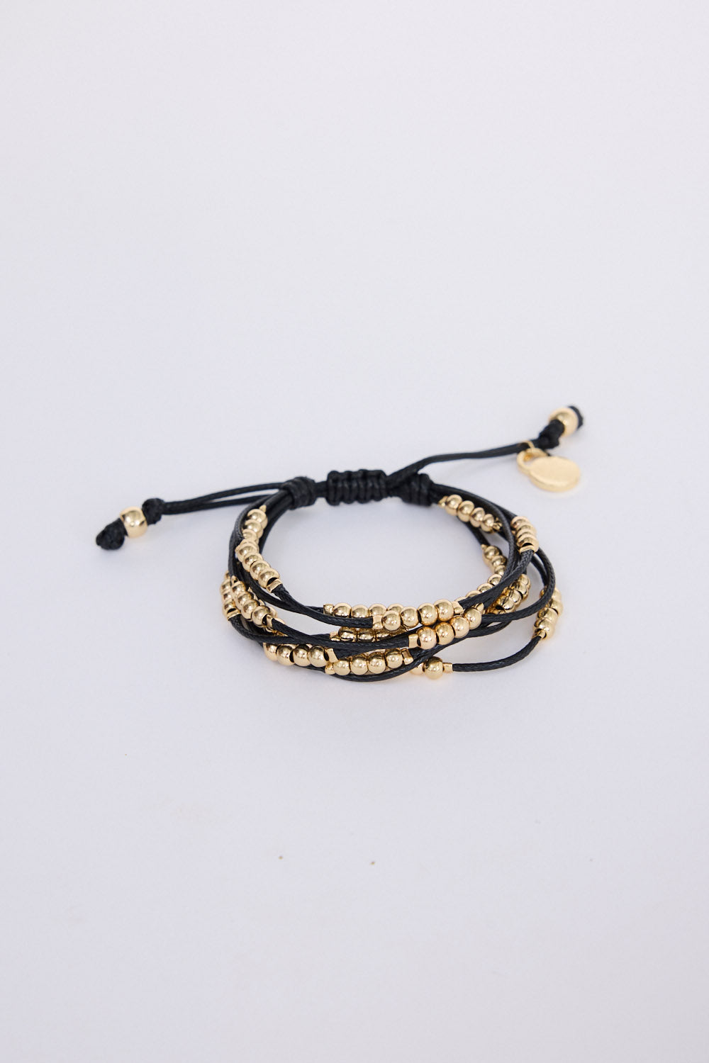 Model wearing Ali Bracelet in black with Gold with mixed bead detailing, on-wrist view on neutral background