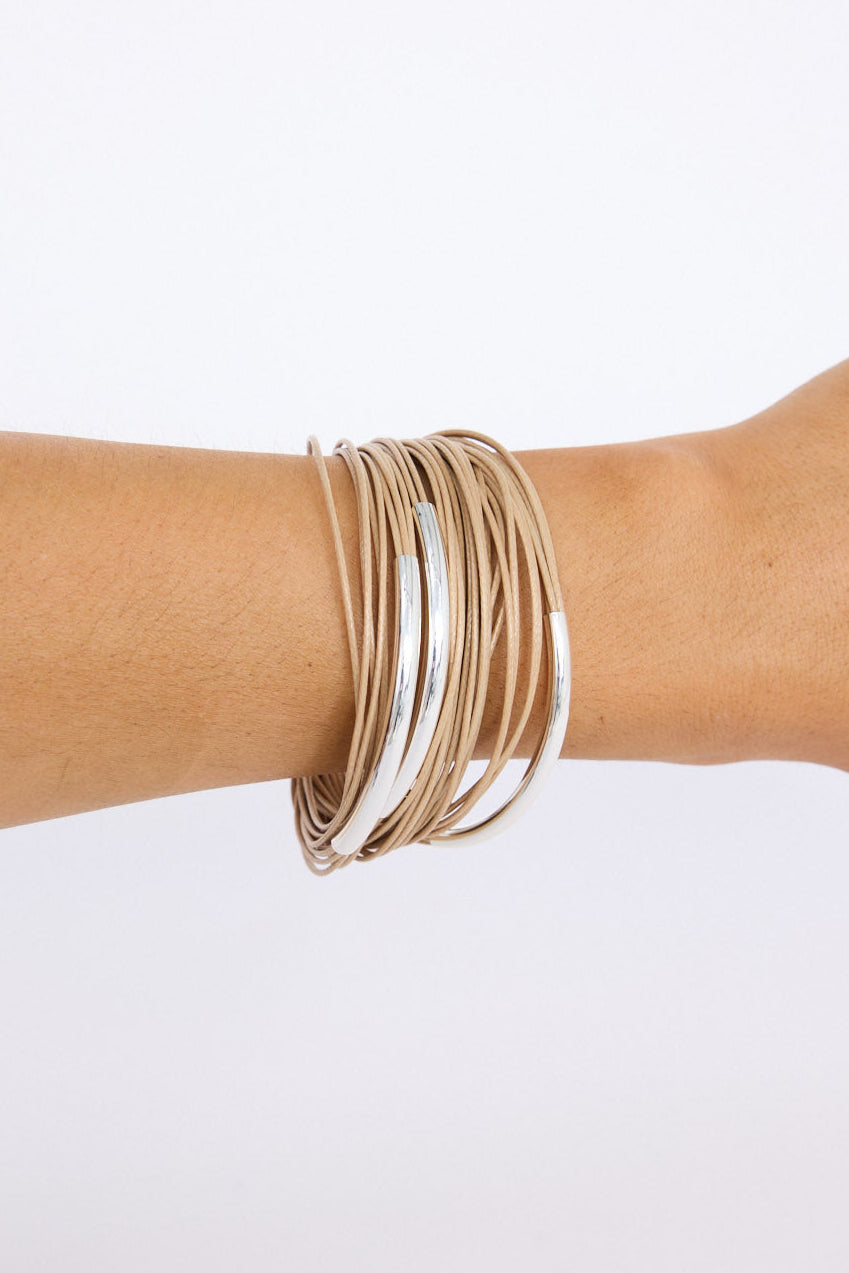 Model wearing Shakira Bracelet in camel with metal accent bars, angled on-wrist view on neutral background