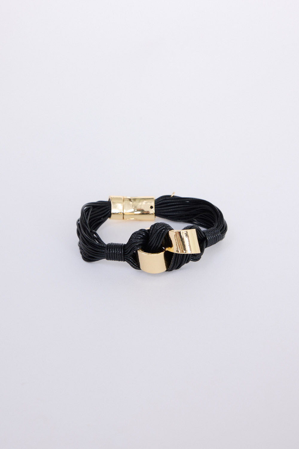 Kazima Bracelet in black with bold knot detailing and metal accents, angled view on white background