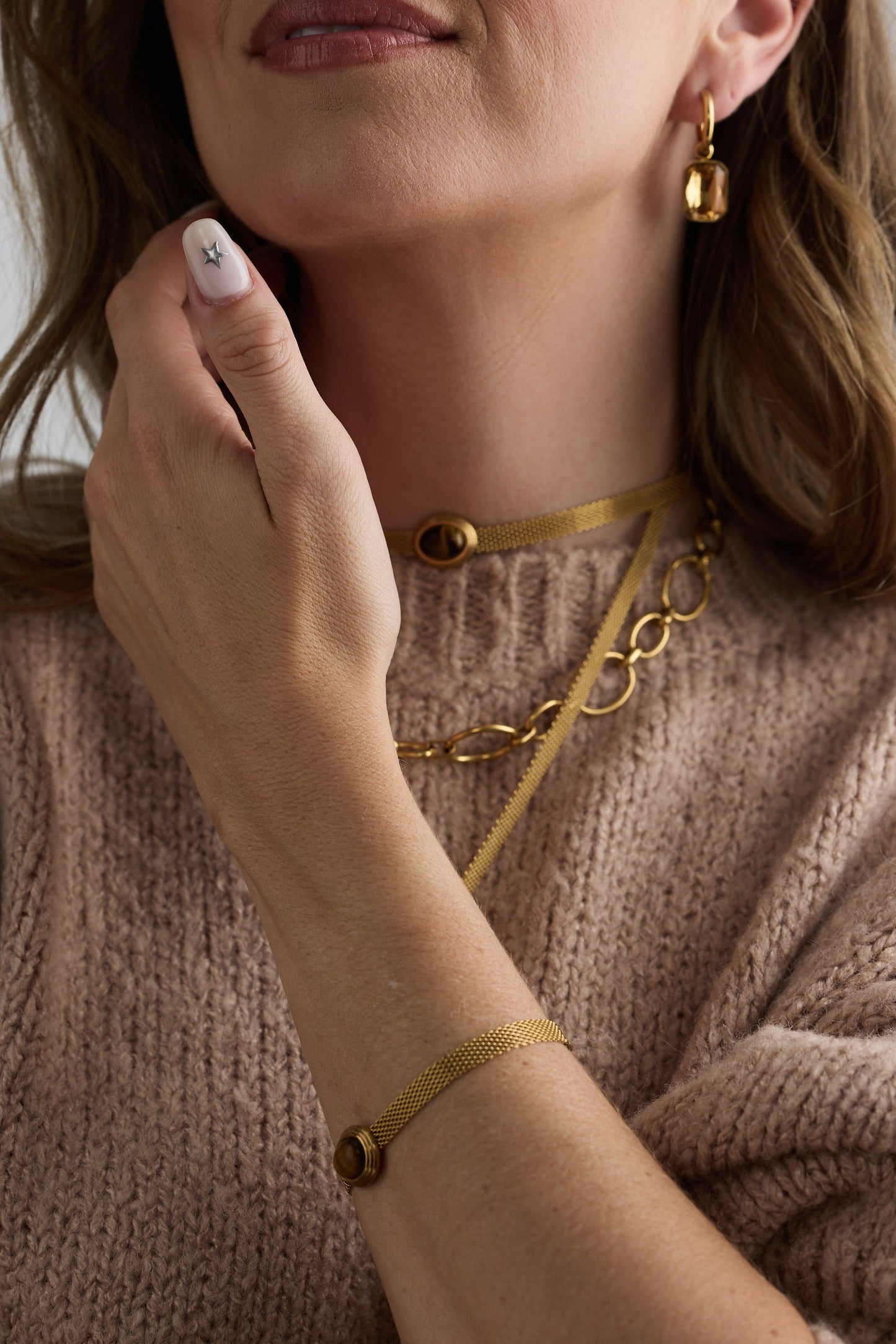 Model wearing Dorris Bracelet in amber with a central oval stone detail, alternate on-wrist view on neutral background