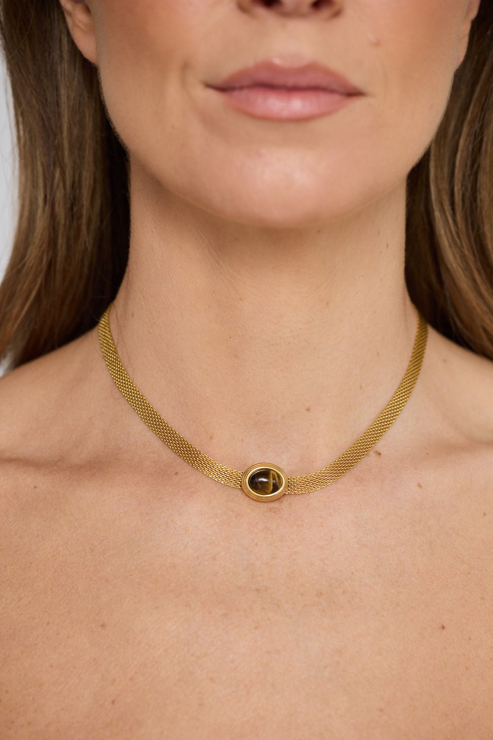 Dorris Necklace in amber with a central oval stone detail, front display view on neutral background