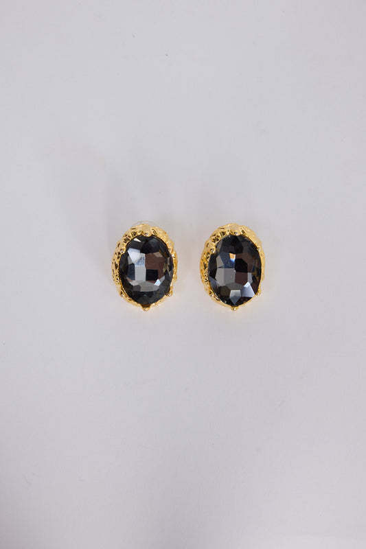 Unice Earrings in smoke with a faceted stone set in a textured gold surround, angled view on white background