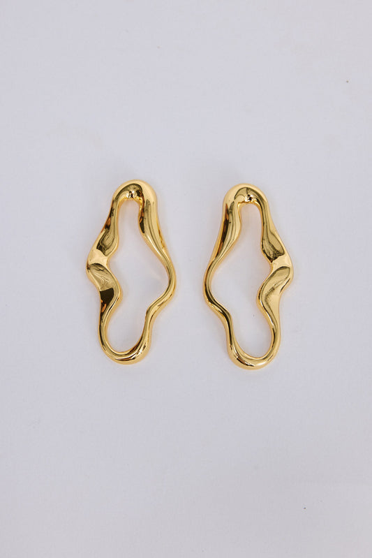 Benny Earrings in gold with a fluid sculptural silhouette, front view on white background