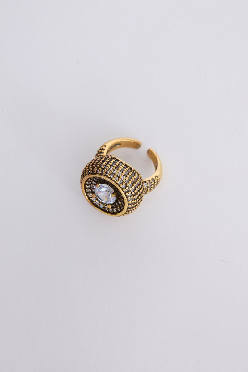 Halo Ring in gold with central stone and textured band detailing, angled view on white background