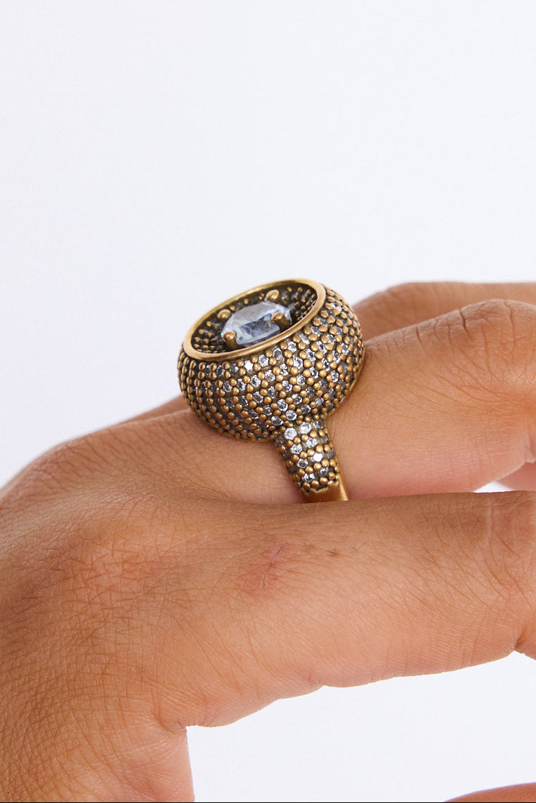 Model wearing Halo Ring in gold with central stone and textured band detailing, model detail view on neutral background