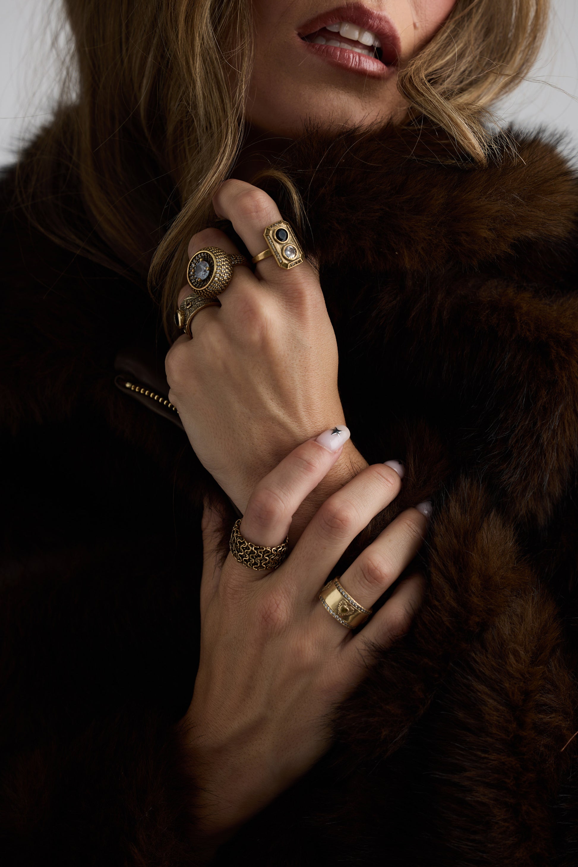 Model wearing Halo Ring in gold with central stone and textured band detailing, alternate hand detail view on neutral background