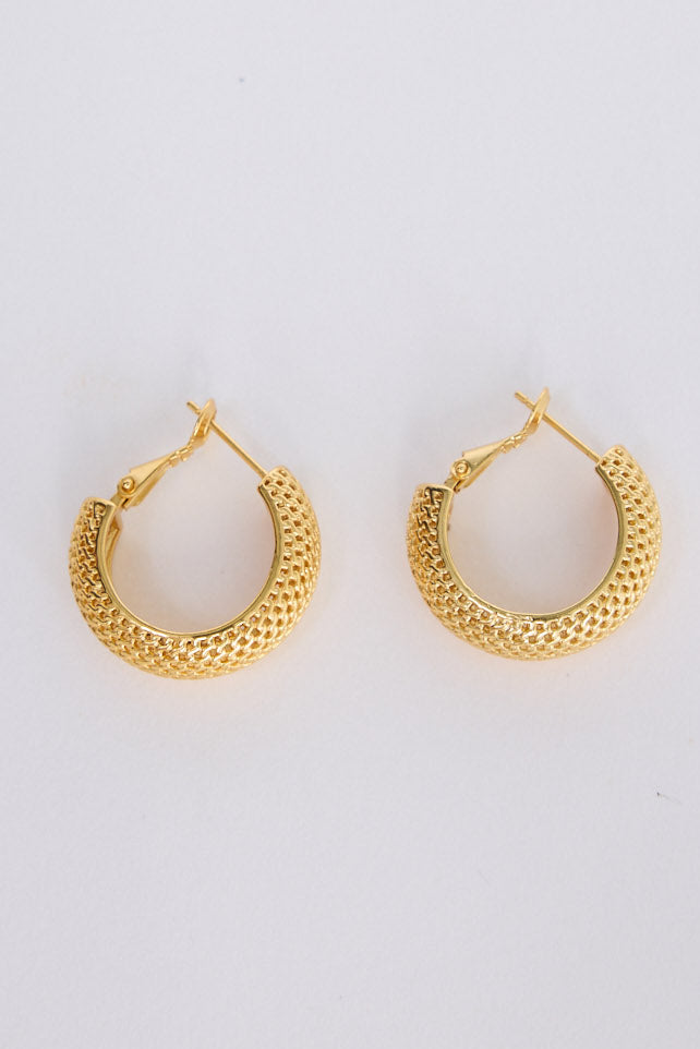 Model wearing Sienna Earrings in gold with textured finish, styled ear close-up on neutral background