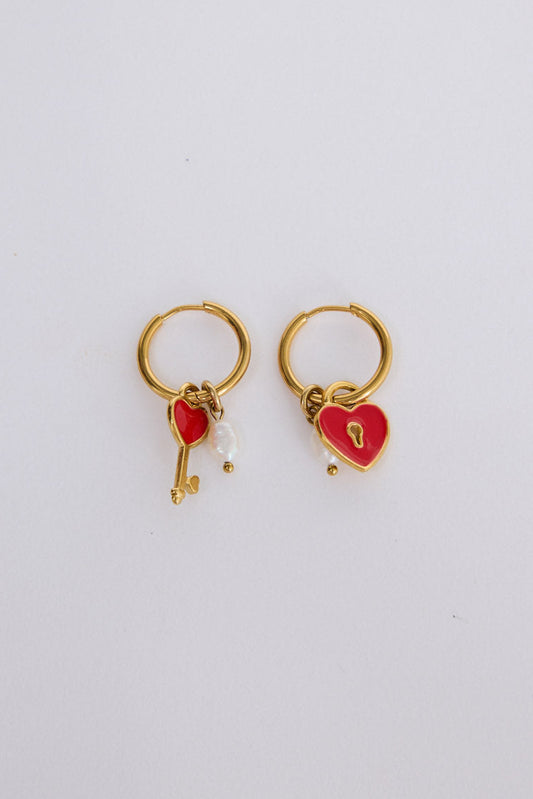 Lockheart Earrings in gold with heart and key charm detailing, angled view on white background