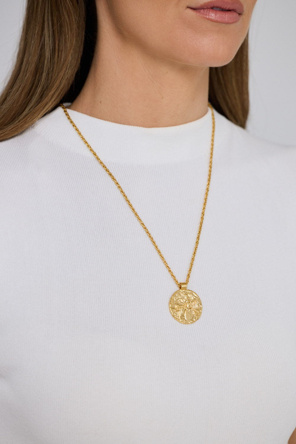 Angelic Necklace in gold with detailed coin charm, front display view on neutral background