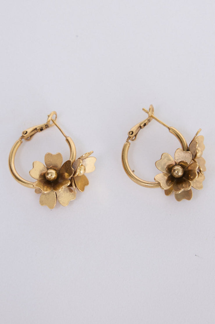 Liucienne Earrings in gold with floral drop detailing, angled view on white background