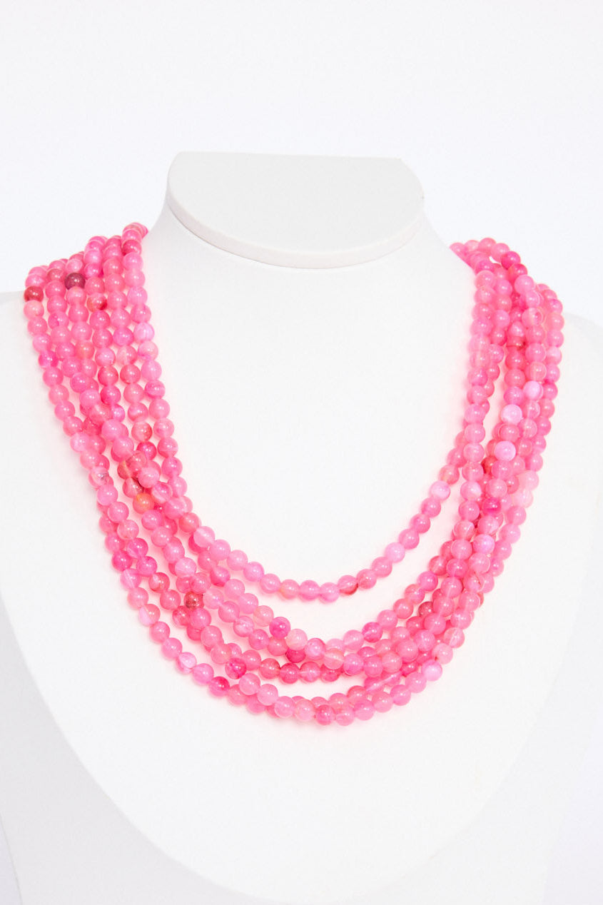 Molly Necklace in hot pink with layered rows of fine rounded beads, front view on white background
