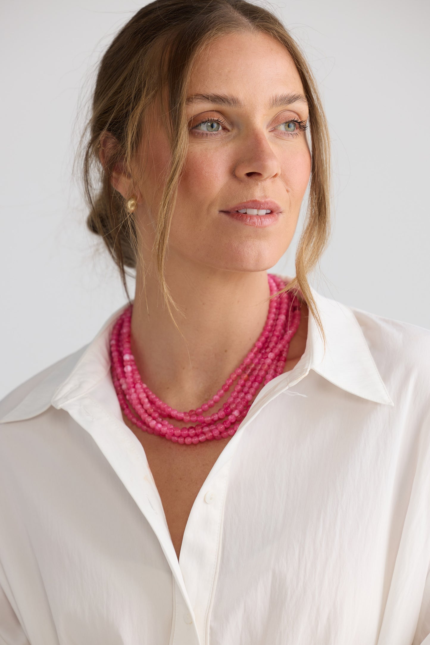 Molly Necklace in hot pink with layered rows of fine rounded beads, pendant close-up view on neutral background