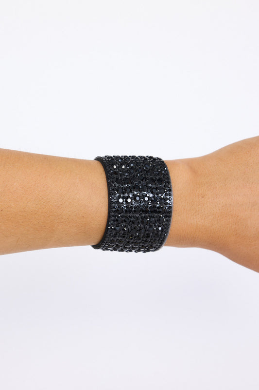 Model wearing Chantelle Bracelet in black with layered textures and embellished detailing, angled on-wrist view on neutral background