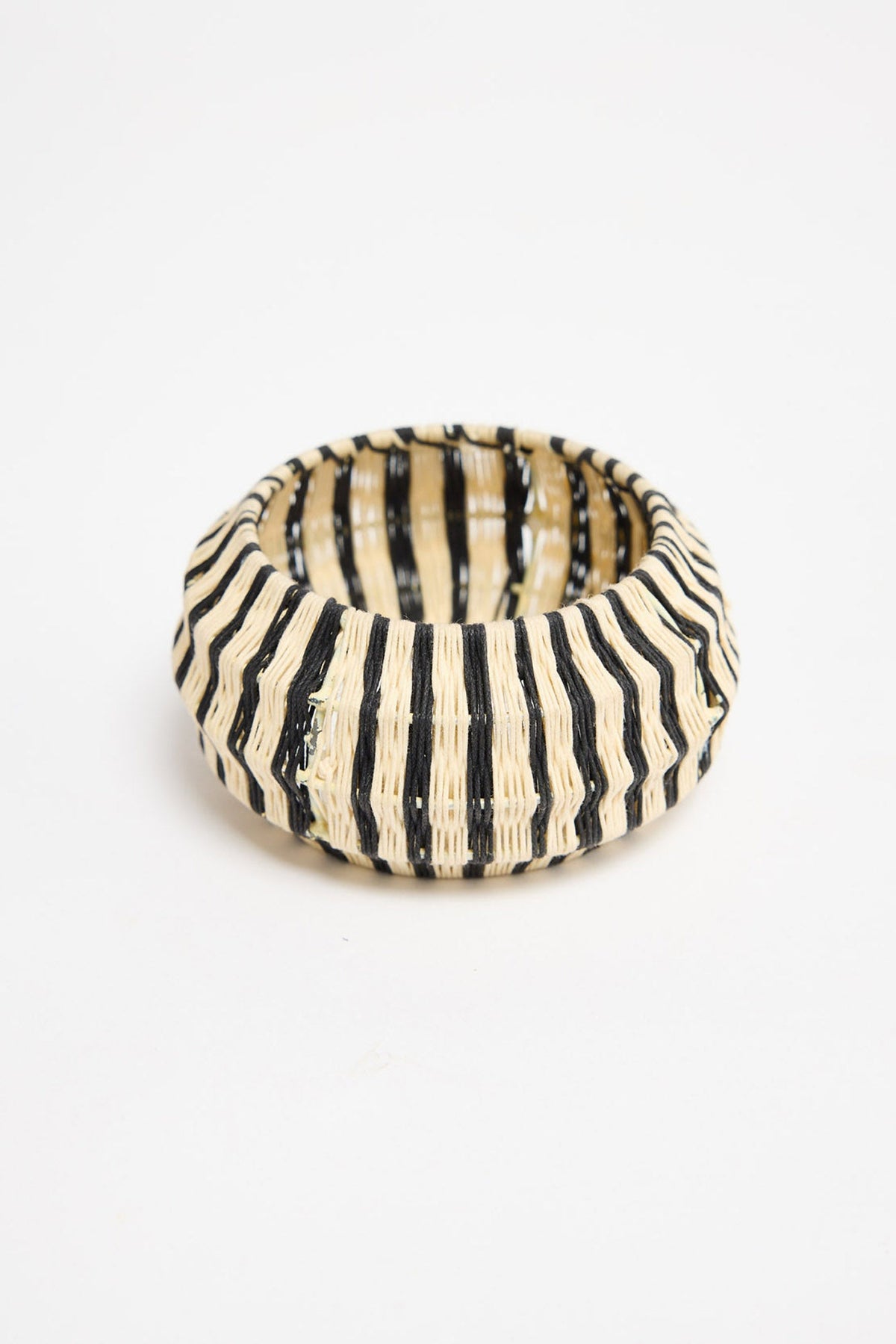 Top-down view of the Lancer Bangle in Stripe showing the woven cotton thread stripe pattern and rounded silhouette