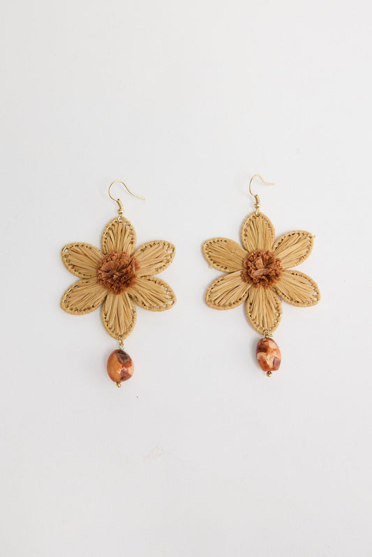 Pair of Tribal Flower earrings in Natural showing woven raffia petals, a textured brown centre and dangling stone bead