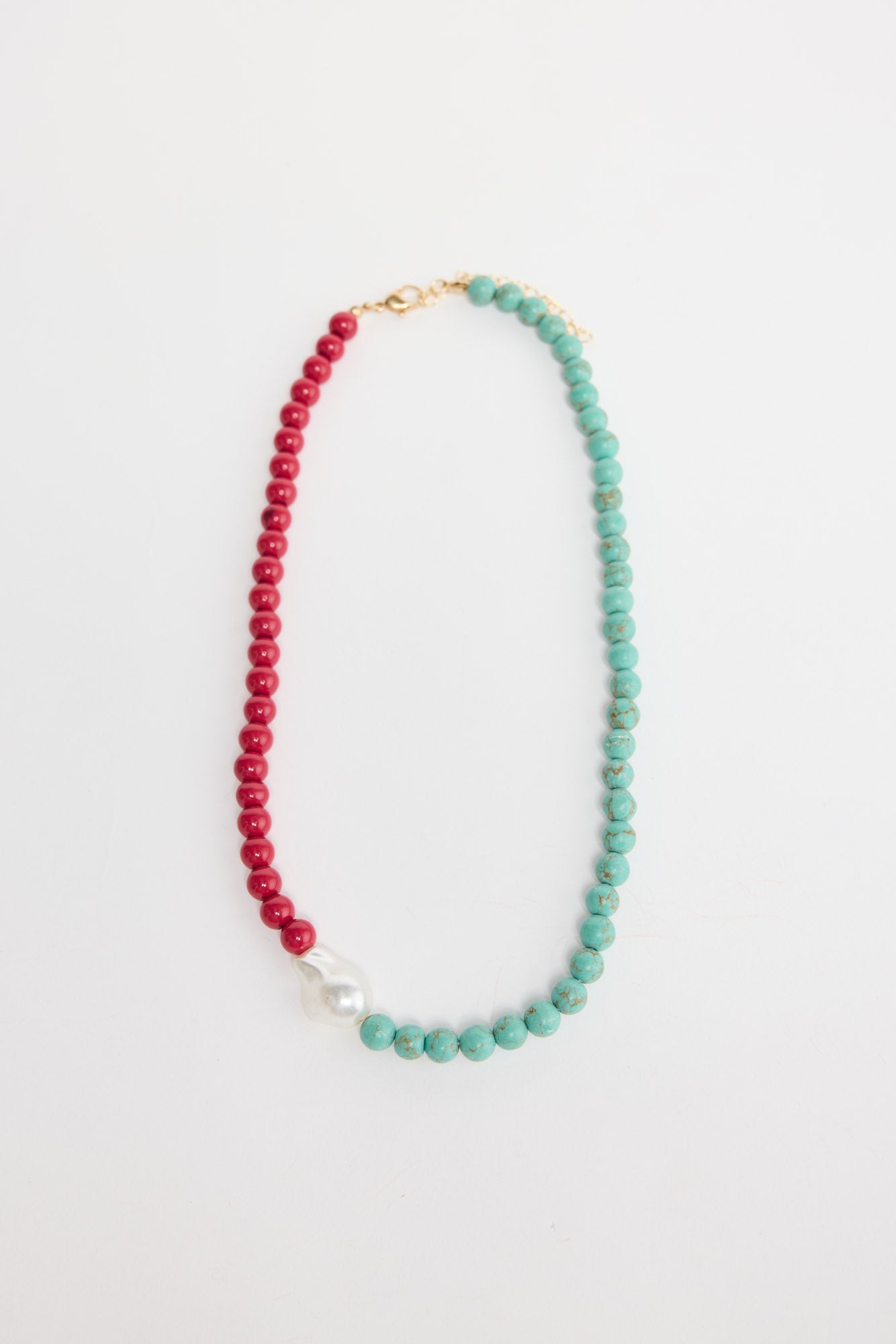 Silas beaded necklace laid flat, showing the two-tone aqua and red bead strand with a baroque pearl accent