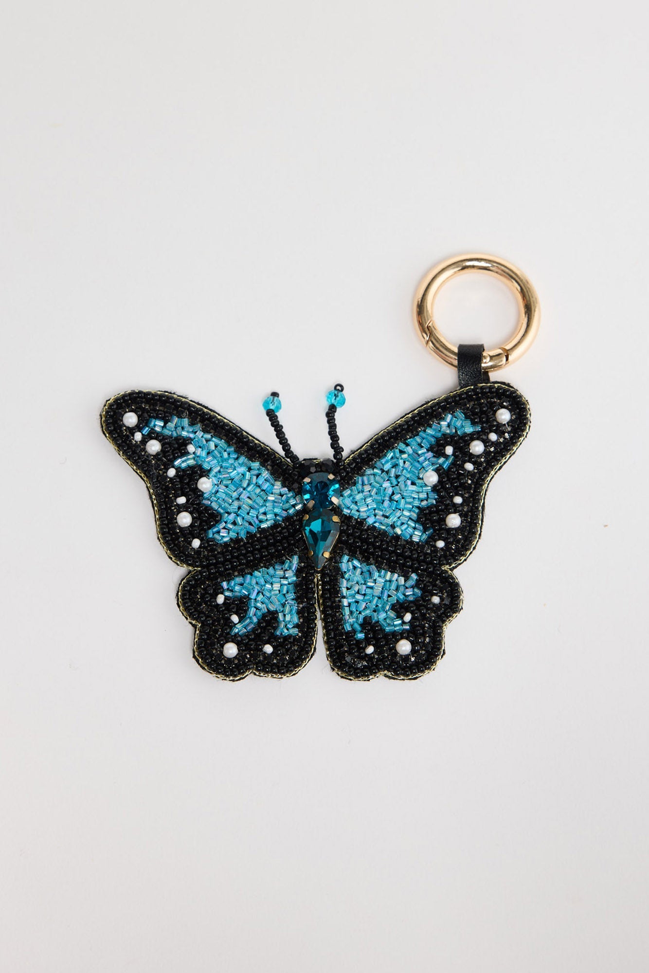 Hand-beaded Butterfly Keyring in Blue laid flat, showing the teal beaded wings with pearl dot detailing and gold-tone clasp