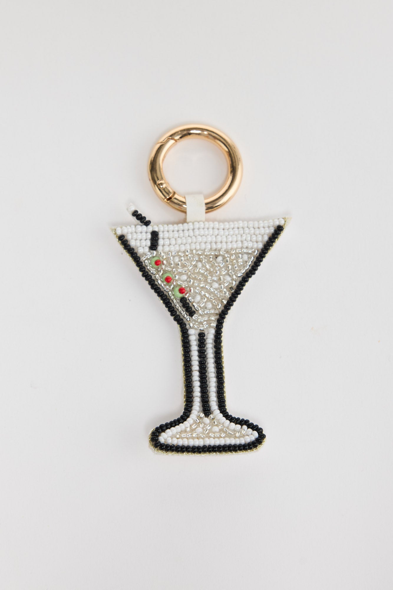 Hand-beaded Martini Keyring in Cream laid flat, showing the beaded glass shape with olive garnish detail and gold-tone clasp