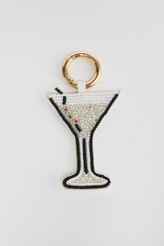Hand-beaded Martini Keyring in Cream laid flat, showing the beaded glass shape with olive garnish detail and gold-tone clasp