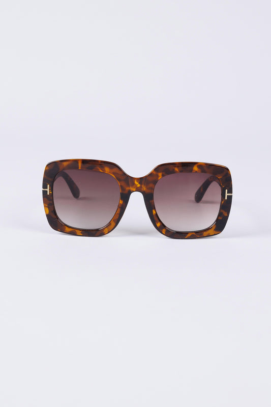 Sunglasses with tortoiseshell frame and gradient lenses on a white background